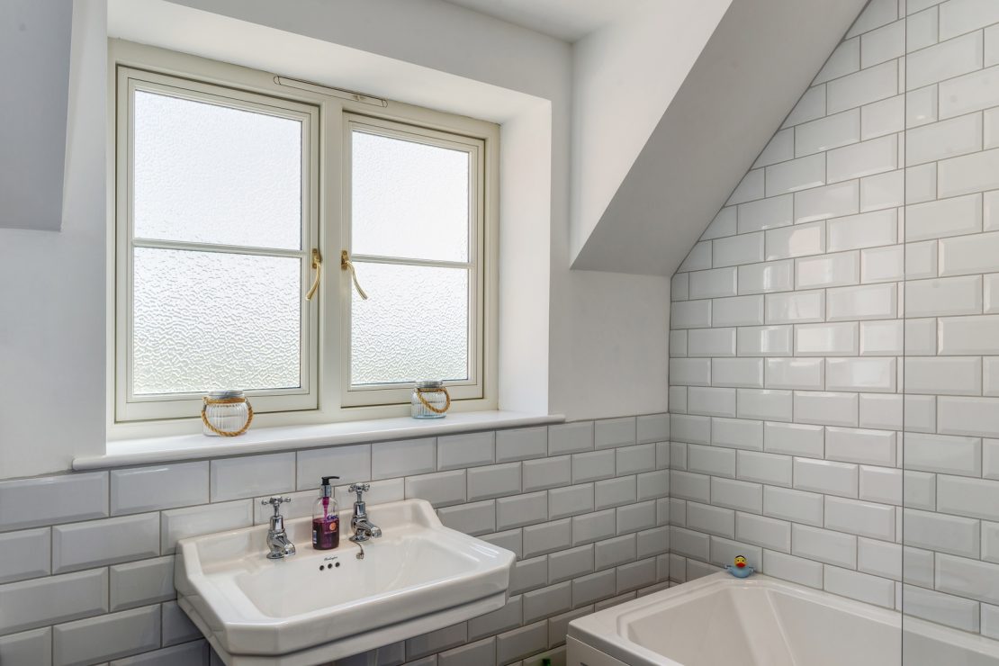 bathroom window with privacy glass and gold hardware