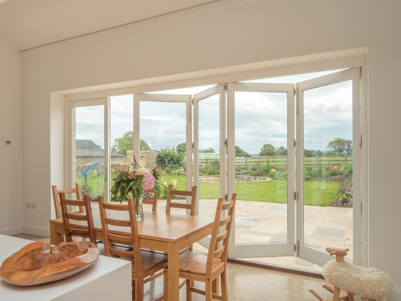 picture of a large set of bifold doors in a kitchen with the countryside in the difference