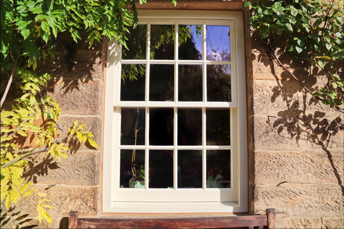 spiral balance sliding sash window with putty glazing painted in cream paint