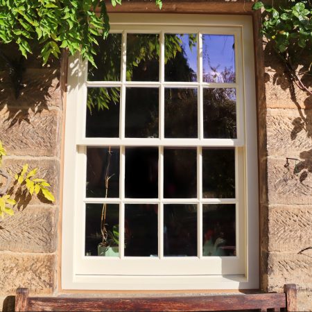 spiral balance sliding sash window with putty glazing painted in cream paint