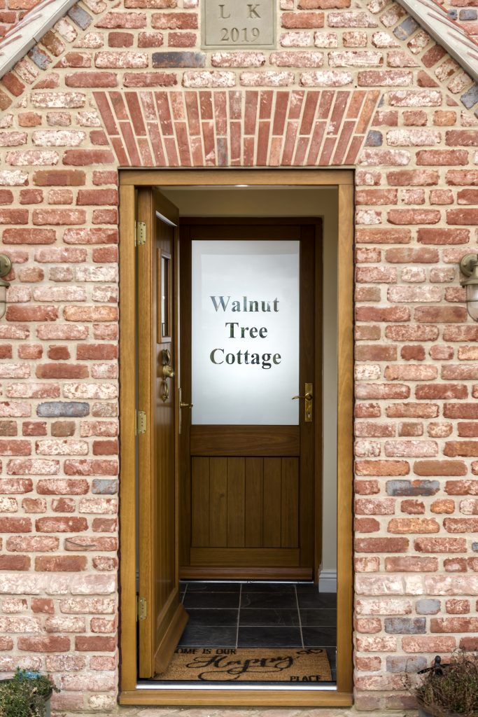 Stained wood entrance foor with etched glass showing house name