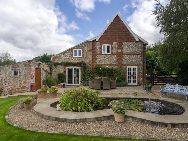 Garden view of traditional farmhouse with George Barnsdale products