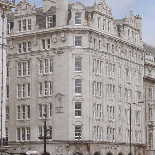 A large, historic white brick building with many floors, traditional windows and mouldings.