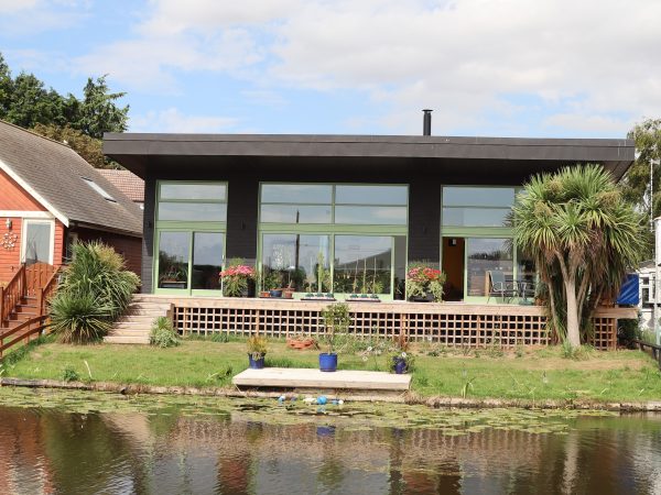black contemporary house with green timber sliding doors
