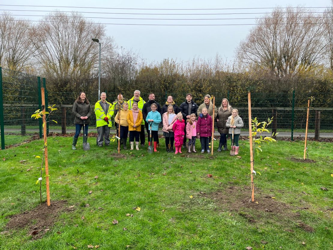Team from George Barnsdale and the proud pupils in their new mini orchard