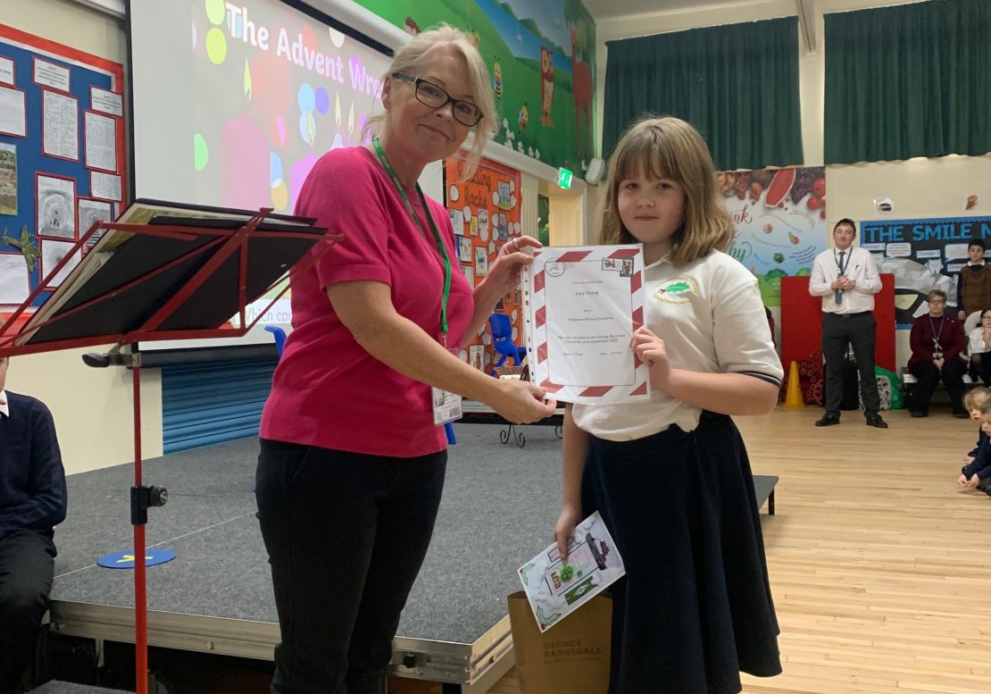 Lucy Young winner of Christmas card competition receiving her prize from tracy Pomfret