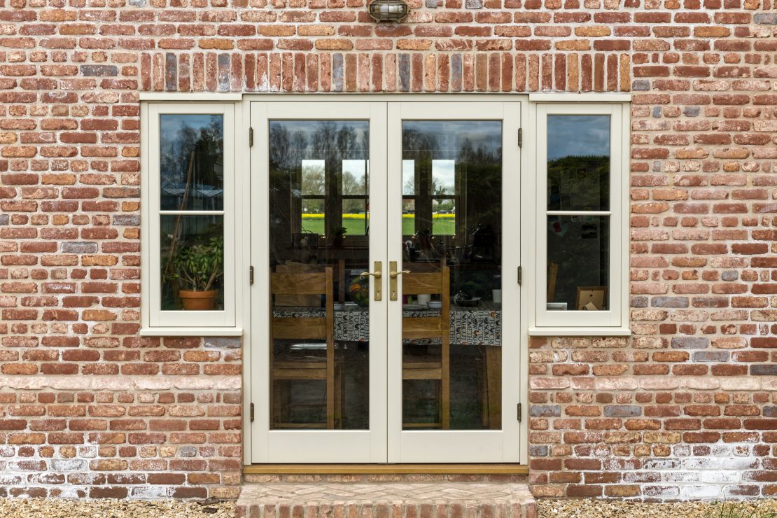 set of cream timber french doors with windows either side in a traditional new build in lincolnshire