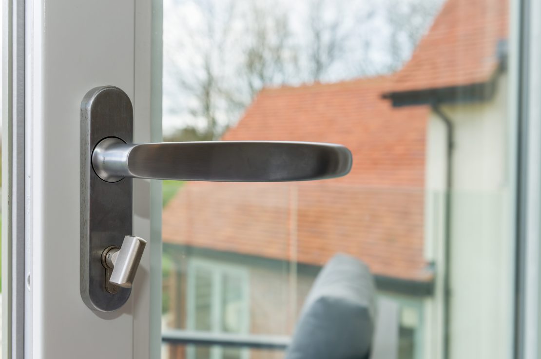Polished chrome handle on white timber sliding patio door