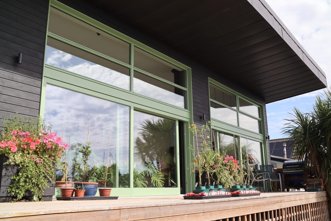 green sliding patio doors on a house beside the river Witham