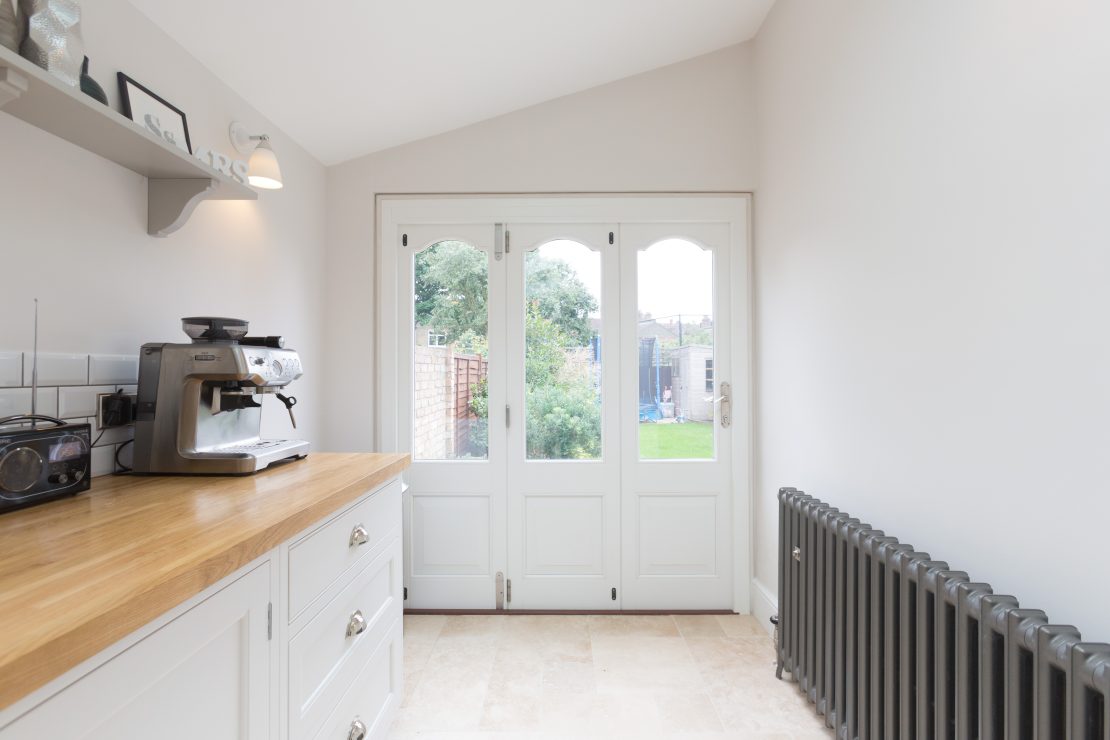 part glazed, part panelled timber bifold door made to match traditional french doors