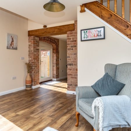 view from lounge through to kitchen french doors with original oak beams and hardwood floors.