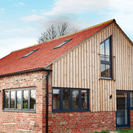 former Yorkshire Piggery converted into a residential property with timber windows and doors painted in dark grey